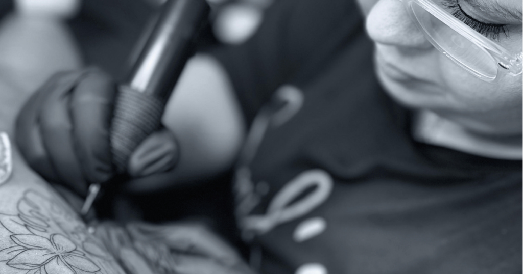 Tattoo-Artist bei der Arbeit: Detailaufnahme einer Tätowiermaschine auf der Haut