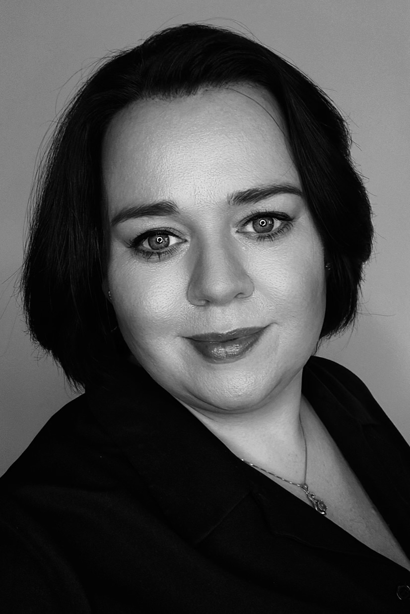 Schwarz-weißes Porträt einer Tattoo Artist, ruhig und konzentriert, mit direktem Blick und klarer Ausstrahlung.